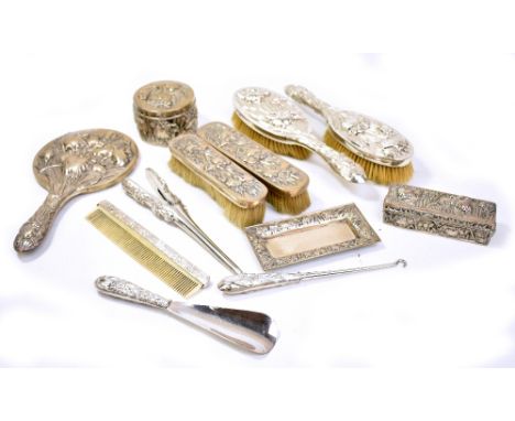 A good and extensive Chinese Export dressing table set, deeply relief decorated with floral sprays comprising hand mirror, a 
