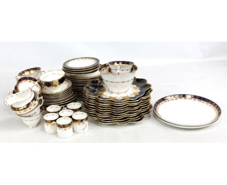 ROYAL WORCESTER; a porcelain tea and coffee set gilt heightened with vines and grapes to blue cobalt border, pattern number 4