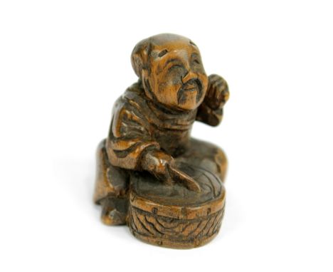 A 19th century Japanese carved wooden netsuke of a seated boy beating a drum, height 3.7cm.Additional InformationLight surfac