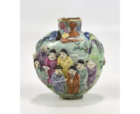 A 19th century Chinese porcelain Famille Rose snuff bottle decorated with gentlemen at a gathering or feast in relief, Qianlo