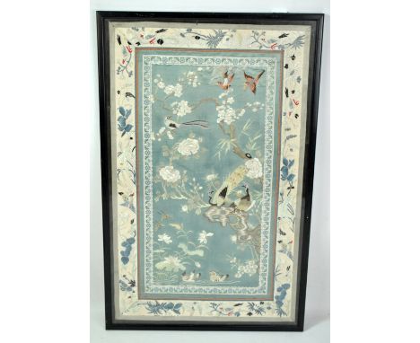An early 20th century Chinese embroidered silk panel depicting birds of Paradise among peonies, lotus flowers and prunus blos