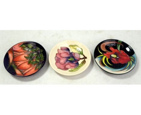 MOORCROFT; three floral tubeline decorated pin dishes including 'Magnolia' pattern example on cream ground, all with impresse