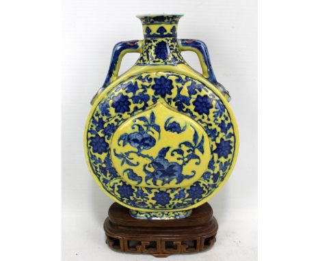 An early 20th century Chinese porcelain Ming-style moonflask, painted in underglaze blue with fruit, bats and flowers, set wi