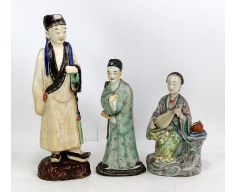 Three Chinese figures of scholars, the two smaller in porcelain and the taller earthenware, the smallest holding pipa (lute) 