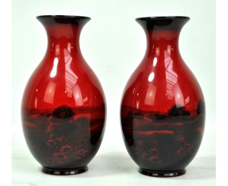 ROYAL DOULTON; a pair of 'Flambe' baluster vases with flared rims and transferred decoration of cottage and church in landsca
