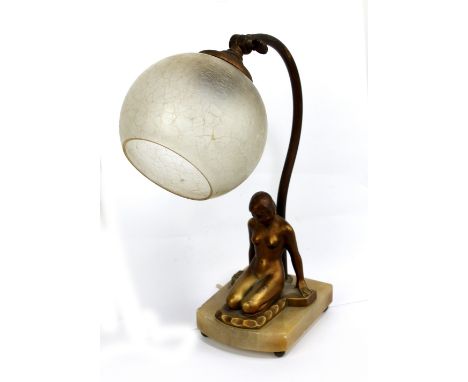 A period Art Deco gilt metal table lamp with original crackle glazed globular shade, angled arm and onyx base mounted with a 