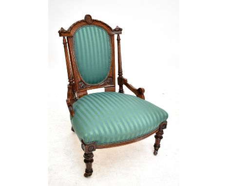A Victorian walnut lady's salon chair with ring turned front legs on castors.
