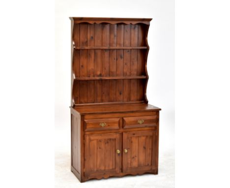 A stained pine dresser with two-shelf plate rack above two short drawers and twin cupboard doors, 161.5 x 94cm.