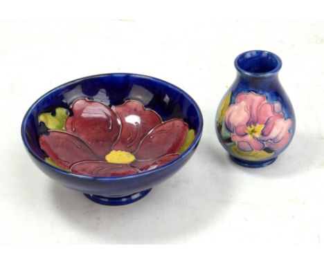 MOORCROFT; a navy ground 'Clematis' pattern tubeline decorated bowl on tapered foot, diameter 14.5cm, and a small 'Magnolia' 