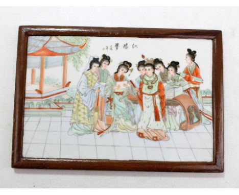 A Chinese rectangular porcelain plaque painted in enamels with eight robed ladies in pavilion/pagoda setting featuring gilt d