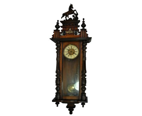 A late 19th century mahogany eight day Vienna wall clock, the case surmounted by a horse above the chapter ring set with Roma