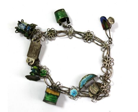 A 1930s Chinese base metal and enamel detailed charm bracelet suspending six charms to include Buddhist auspicious symbols, l