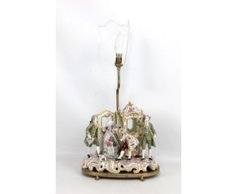 An early 20th century Continental porcelain figure group depicting a pair of courtly figures and their dog beside two footmen