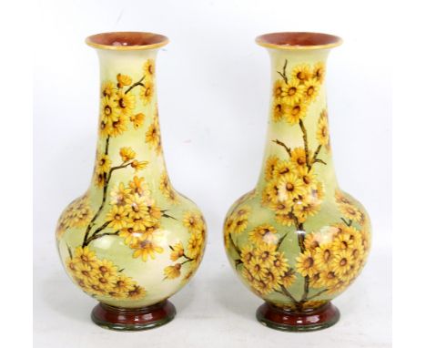 LAMBETH FAIENCE; a pair of Art Nouveau vases hand painted with blossoming branches, impressed marks to base also with artist'