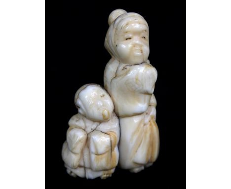 An early 20th century Japanese carved walrus ivory netsuke of a woman and child, height 5cm.Additional InformationSlightly ru