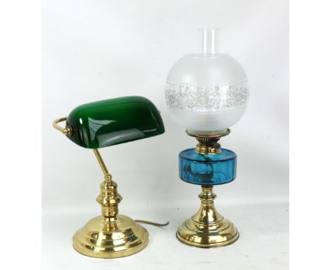 A brass oil lamp with blue glass reservoir, clear glass chimney and etched shade, height 51cm, and a library/reading light wi