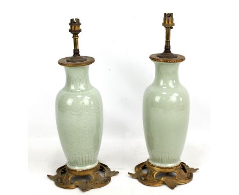 A pair of 20th century Chinese celadon glazed porcelain baluster vases with incised decoration of lotus beneath band of plant