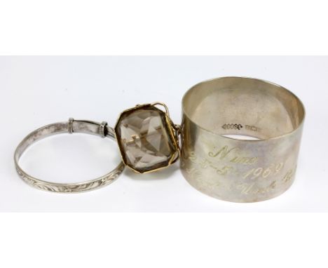 A hallmarked silver napkin ring with presentation inscription, a child's silver bangle, and a 9ct yellow gold dress ring (3).