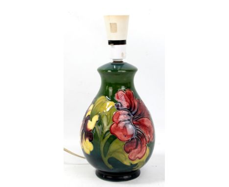 MOORCROFT; a 'Hibiscus' pattern tubeline decorated lamp base on green ground with impressed marks to base, height excluding f