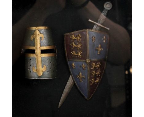 A medieval-style diorama of helmet, sword and shield, framed and glazed.&nbsp;