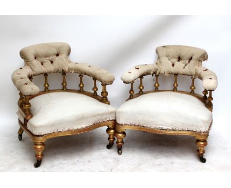 A pair of 19th century gilt framed tub chairs, in need of restoration and upholstery, with ring turned front legs to castors 
