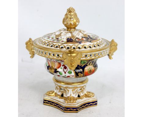 DERBY; a 19th century pot pourri bowl and cover, with gilt heightened finial above four applied masks, raised on gilt heighte