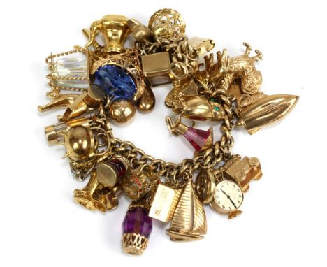A 9ct yellow gold charm bracelet set with thirty charms including crown, miner's lamp, football, owl, book, etc, total approx