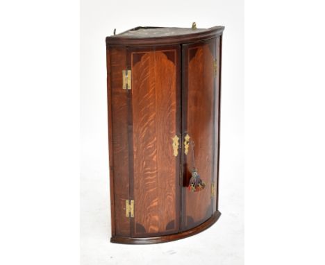 A George III oak and mahogany corner cupboard with twin doors enclosing three shelves, width 58cm.Additional InformationGener