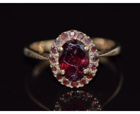 A 9ct gold ring set with garnets in an oval cluster, 2.4g, size K&nbsp;