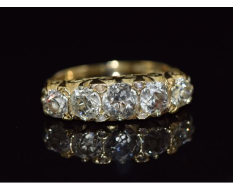 An 18ct gold ring set with five old cut diamonds measuring 0.65, 0.45, 0.45, 0.3ct &amp; 0.3ct interspersed with rose cut dia