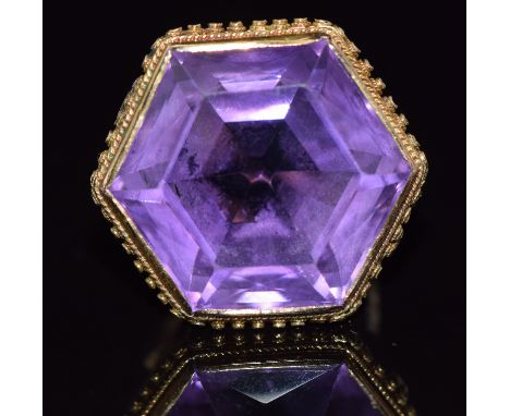 A 9ct gold ring set with a large hexagonal amethyst with a rope and sphere border, 9.9g, size K