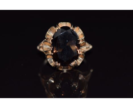 A 9ct gold ring set with an oval cut smoky quartz, 4.8g, size K/L