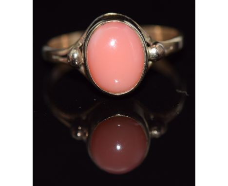 A 9ct gold ring set with an oval coral cabochon, 1.9g, size J/K&nbsp;