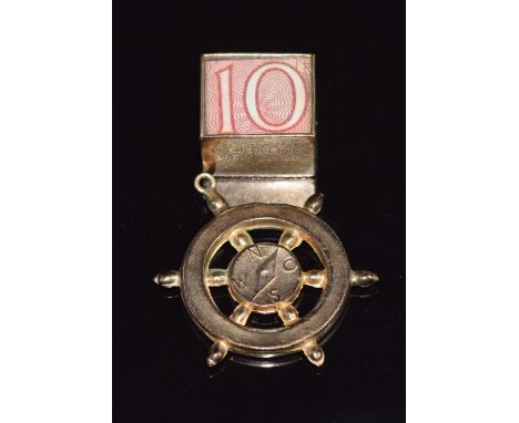 A 9ct gold charm in the form of a compass and a 9ct gold charm set with a 10 shilling note, 4.8g