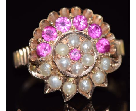 A yellow metal ring set with round cut rubies and seed pearls in a cluster, size K, 4.3g