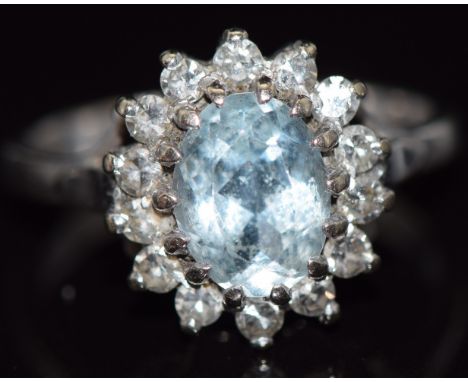 An 18ct white gold ring set with an oval cut aquamarine surrounded by diamonds, 4.6g, size K&nbsp;