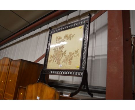An early 20th Century carved mahogany and embroidered firescreen