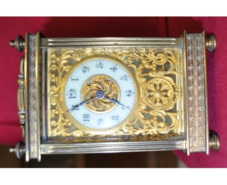 Brass cased carriage clock,
having enamel dial with pierced brass scrolled back plate, reeded columns and turned feet, height