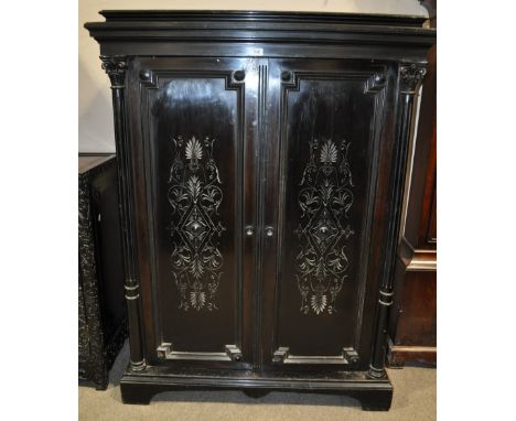 A late Victorian ebonised side cabinet,
having 2 carved panelled doors with split turned pilasters on a bracket base, width 3