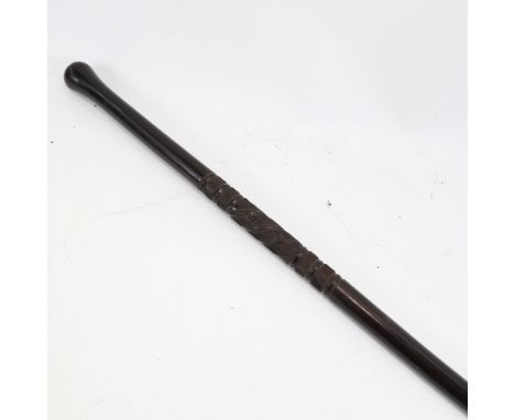 An ebony baton stick with spiral carved design, possibly military, length 61cm 