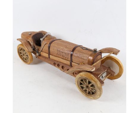 A handmade carved wood model sculpture of a Veteran racing car, by Clive Fredriksson, length 39.5cm 