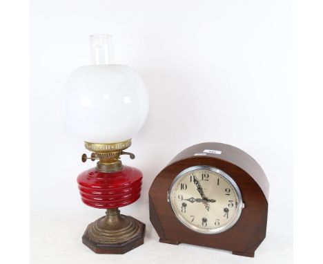 An Enfield 3-train mantel clock, and an oil lamp with red font, chimney and shade, height 48cm 