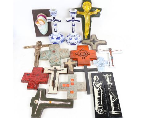 A quantity of glazed ceramic crucifixes and religious symbols, and a pair of porcelain candlesticks in the form of crucifixes