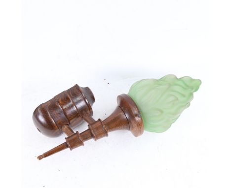 An Art Deco wall-mounted oak lamp, with green glass flame design shade, 38cm overall.The flame shield is in good condition. H