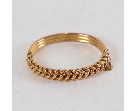 An early 20th century 10ct gold rope twist hinged bangle, internal dimensions 5.5cm x 5cm, 16.1g 