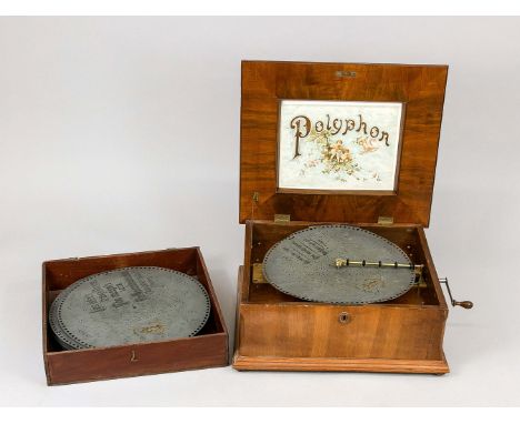 Polyphon (Lochplattenspieler), um 1900. Holzkasten mit Scharnierdeckel auf 4 Füßchen, seitlich Kurbel, eine Lochplatte liegt 