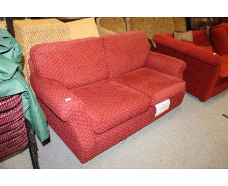 A RED UPHOLSTERED PATTERNED SOFA