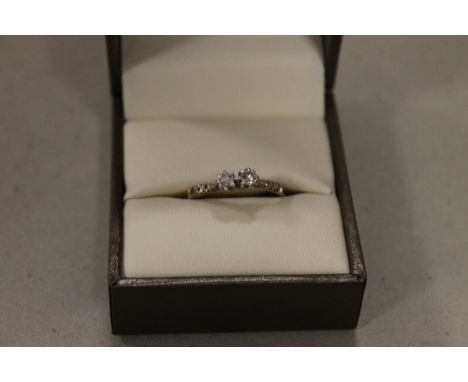 A BOXED 9CT TWO STONE DIAMOND RING HAVING SIX SMALLER DIAMONDS TO THE SHOULDERS