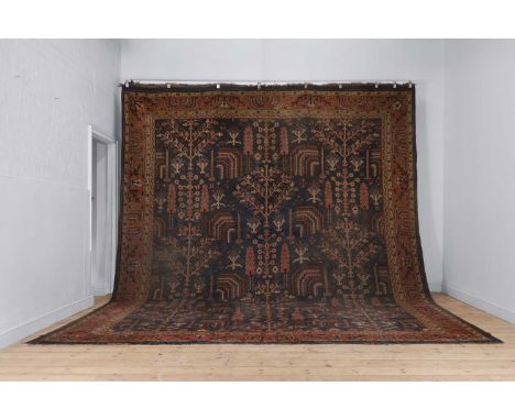 An Oushak wool carpet, early 20th century, Turkish, woven with geometric foliate motifs to a blue ground, with 'Maple &amp; C