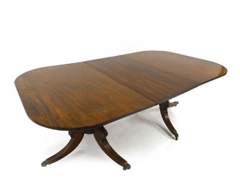 A Regency-style mahogany twin pillar dining table late 19th century, with D shape reeded ends and central leaf, on turned bul
